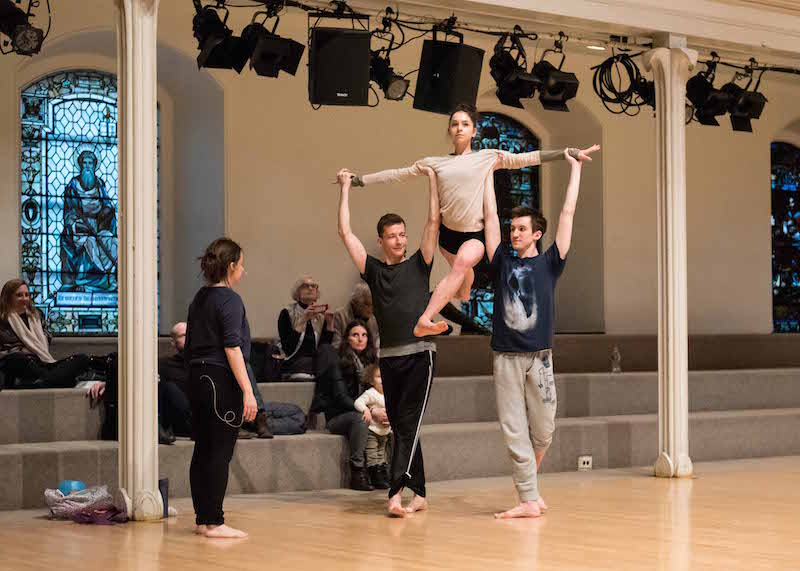 Pam Tanowitz directs her dancers as two men lift a female in an overhead position